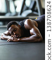 Young black man resting on a gym floor after an intense workout session 138708624