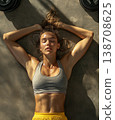 Young woman resting on a gym floor after an intense workout session 138708625