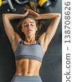 Young woman resting on a gym floor after an intense workout session 138708626