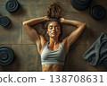 Young woman resting on a gym floor after an intense workout session 138708631