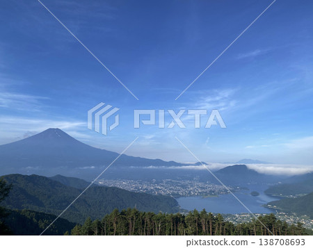 Under the clear blue sky of early summer, the majestic, spreading Mount Fuji stands majestically, with layers upon layers of low mountains stretching from the Misaka mountain range towards Fuji, and Lake Kawaguchi filled with water. 138708693