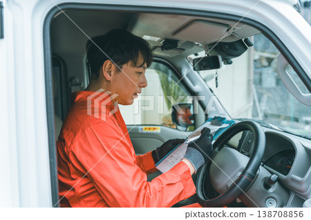 一輛輕型貨車和一個穿著工作服的男人 138708856