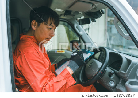 一輛輕型貨車和一個穿著工作服的男人 138708857