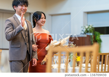 New wedding ceremony: The bride and groom enter the reception hall carrying their bouquets. New wedding ceremony: The bride and groom enter the reception hall carrying their bouquets. 138709430