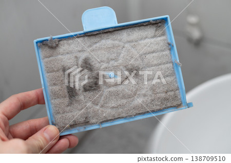 Close up of a very dirty vacuum cleaner filter clogged with dust and debris Close up of a very dirty vacuum cleaner filter clogged with dust and debris 138709510