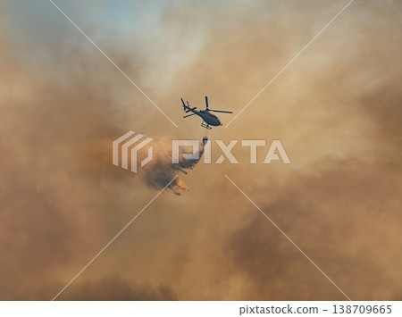Fire fighting helicopter carry watethar bucket to extinguish the forest fire. 138709665