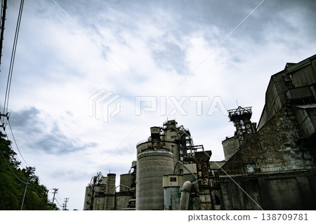 Exterior view of a factory with multiple large tanks and exposed steel beams. Exterior view of a factory with multiple large tanks and exposed steel beams. 138709781