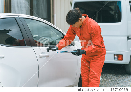 一輛轎車和一個穿著工作服的男人 一輛轎車和一個穿著工作服的男人 138710089