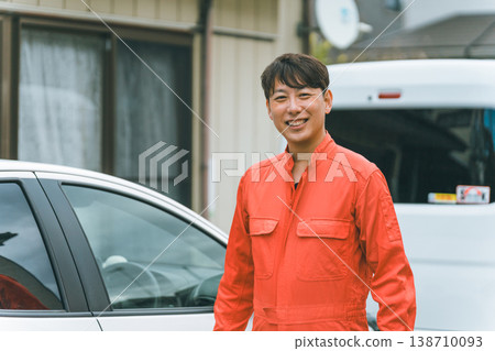 一輛轎車和一個穿著工作服的男人 一輛轎車和一個穿著工作服的男人 138710093