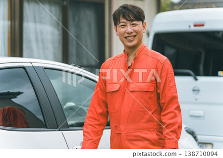一輛轎車和一個穿著工作服的男人 一輛轎車和一個穿著工作服的男人 138710094