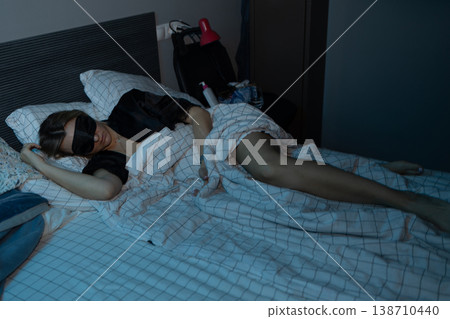 Peaceful young woman sleeping on white sheets with black eye mask in bedroom photography. Peaceful young woman sleeping on white sheets with black eye mask in bedroom photography. 138710440