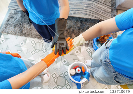 Cleaning team uniting hands in a gesture of teamwork Cleaning team uniting hands in a gesture of teamwork 138710679