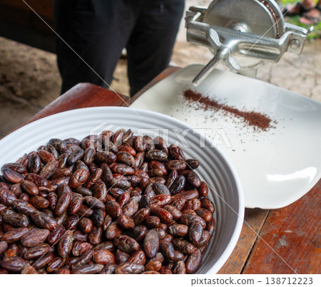 Roasted cacao beans being ground for chocolate production 138712223