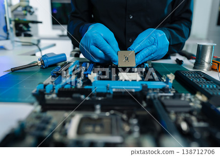 Computer Hardware Technician Repairing Motherboard with Soldering Iron in Electronics Lab. 138712706
