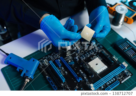 Computer Hardware Technician Repairing Motherboard with Soldering Iron in Electronics Lab. 138712707