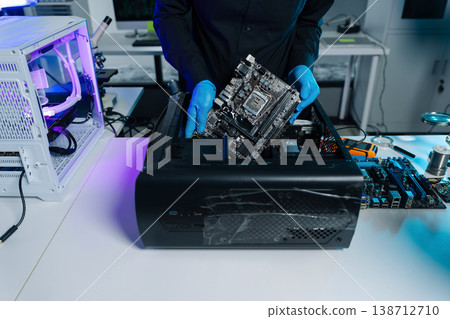 Computer Hardware Technician Repairing Motherboard with Soldering Iron in Electronics Lab. 138712710