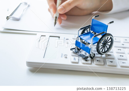 Wheelchair and calculator: Image material for nursing care costs and nursing care worker salaries. 138713225