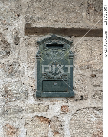 Vintage metal mailbox on rustic stone wall, suitable for backgrounds or historical themes 138713607