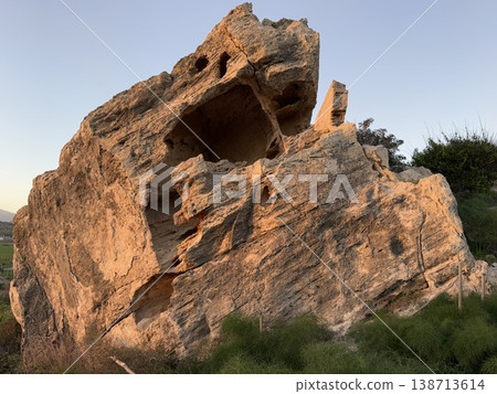 Large rock formation in natural landscape with sunlight illuminating surface texture Large rock formation in natural landscape with sunlight illuminating surface texture 138713614