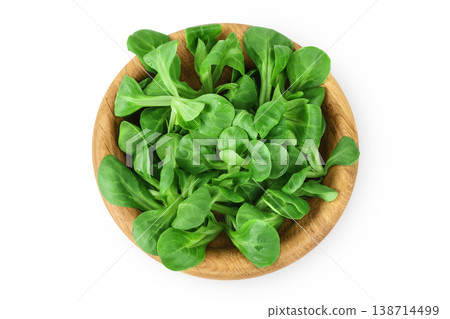 Valerian leaves salad. Corn salad in wooden bowl isolated on white backgrounds. Lettuce salad. Top view 138714499