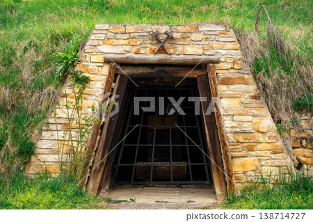 View of the entrance to an old stone mine covered with a steel grate. View of the entrance to an old stone mine covered with a steel grate. 138714727