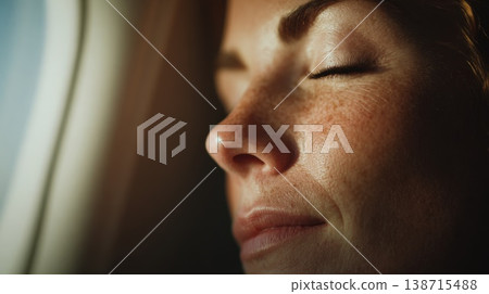 Woman resting by airplane window Woman resting by airplane window 138715488