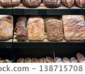Fresh bread displayed on shelves in a bakery during daytime hours in a busy market area in the city 138715708