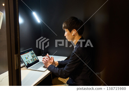 一位來自外國公司的年輕男性系統工程師在一個私密的專注隔間裡參加線上會議。 一位來自外國公司的年輕男性系統工程師在一個私密的專注隔間裡參加線上會議。 138715980