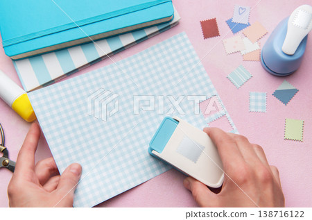 Hand using punch tool creating decorative craft stamps Hand using punch tool creating decorative craft stamps 138716122