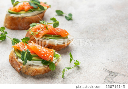Savory salmon avocado bruschetta with microgreens and sesame seeds Savory salmon avocado bruschetta with microgreens and sesame seeds 138716145