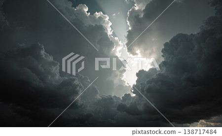 Dramatic sun rays breaking through dark storm clouds in a moody sky. 138717484