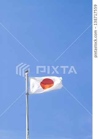 The Japanese flag fluttering against a blue sky. 138717559