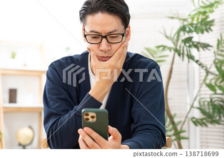 A man who is worried about seeing a smartphone A man who is worried about seeing a smartphone 138718699