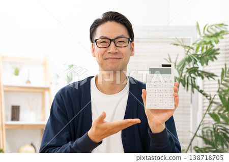 A man holding a calculator and waving his hand. A man holding a calculator and waving his hand. 138718705