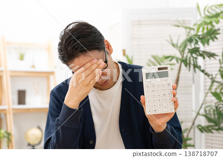 一個拿著計算器的男人心事重重。 138718707