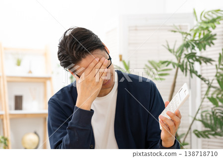 一個拿著計算器的男人心事重重。 138718710