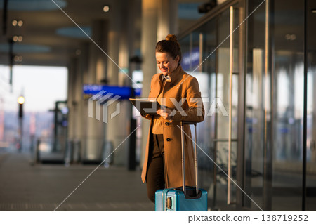 Smiling Professional Woman with Suitcase at Train Hub 138719252