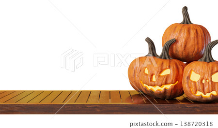 Three carved pumpkins with different faces are placed on a wooden tabletop. The scene shows Halloween decorations ready for celebration. The background is clear and simple 138720318