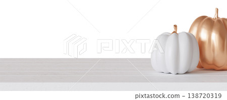 Two pumpkins in white and gold are placed on a tabletop. This setting shows a festive decoration for Halloween. The clear background highlights the pumpkins well 138720319