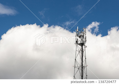 Bottom perspective pov of modern metal steel mobile 5g network wireless telecom tower against clear blue sky background on bright day. Microwave signal broadband equipment base line station mast 138720477