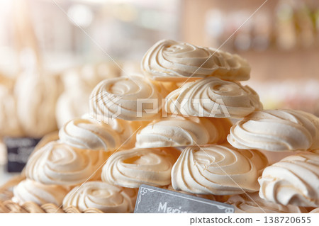 Meringue dessert stack delicate swirls displayed bakery warm light highlighting airy texture sweetness. Closeup food scene showing handmade sugar treat, soft pastel tones and patisserie showcase Meringue dessert stack delicate swirls displayed bakery warm light highlighting airy texture sweetness. Closeup food scene showing handmade sugar treat, soft pastel tones and patisserie showcase 138720655