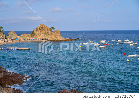 A scenic view of the coast of Tossa de Mar with boats, beachgoers, and the stunning Mediterranean sea. A scenic view of the coast of Tossa de Mar with boats, beachgoers, and the stunning Mediterranean sea. 138720704