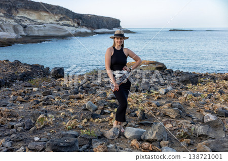 Woman Standing On Rocky Coast With Ocean Background Travel Lifestyle Portrait 138721001