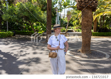 Confident Woman Portrait In Tropical Botanical Garden With Palm Tree And Summer Sunlight Confident Woman Portrait In Tropical Botanical Garden With Palm Tree And Summer Sunlight 138721017