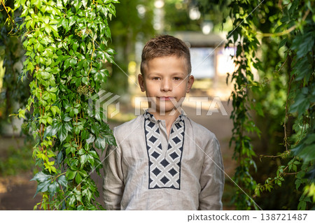 Serious Young Boy Standing Between Green Ivy Leaves Natural Portrait Serious Young Boy Standing Between Green Ivy Leaves Natural Portrait 138721487