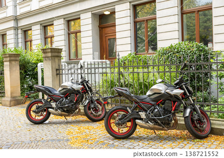 Two Parked Motorcycles On Cobblestone Street In European City Residential Neighborhood Two Parked Motorcycles On Cobblestone Street In European City Residential Neighborhood 138721552