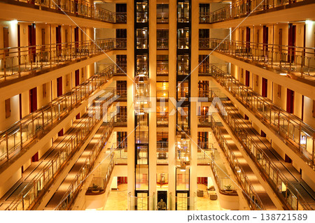 Luxury Hotel Atrium Interior with Glass Elevators and Warm Cinematic Lighting Luxury Hotel Atrium Interior with Glass Elevators and Warm Cinematic Lighting 138721589