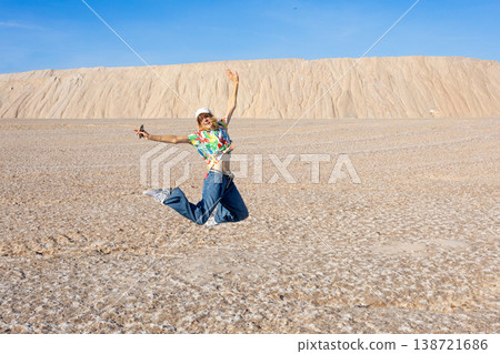 Young Woman Jumping On Salt Flat Landscape With Joyful Freedom And Summer Travel Energy 138721686