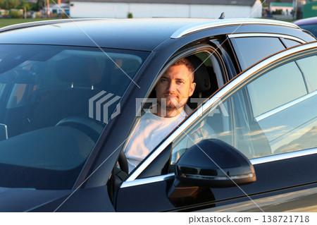 Confident Man Sitting in Car Driver Seat During Golden Hour 138721718
