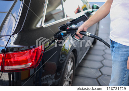 Close Up Of Fuel Nozzle Refueling Modern Car At Gas Station Transportation Energy Concept 138721729